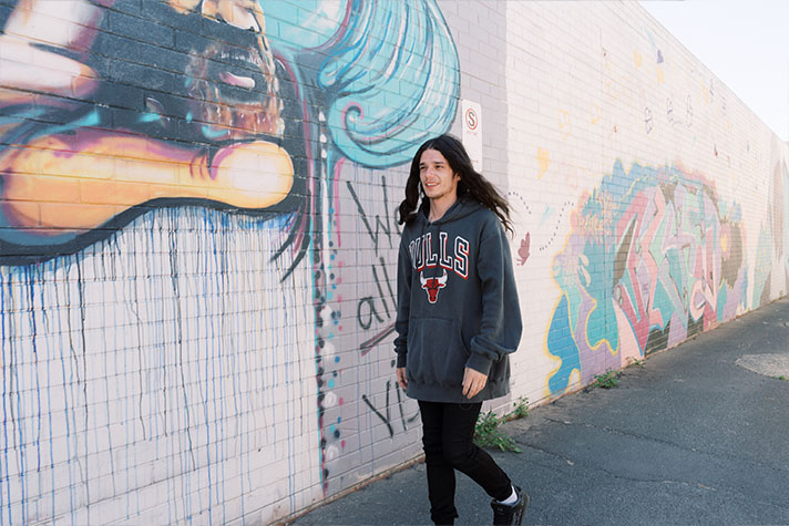 Robert on way to school walking past graffiti wall