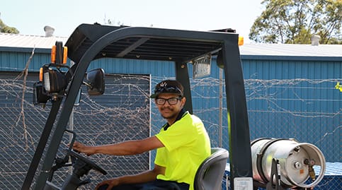 Troy driving a forklift