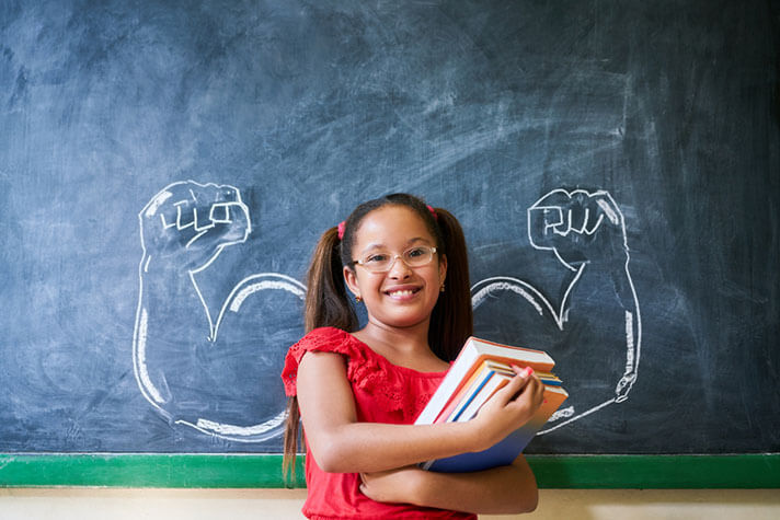 Child standing strong in front of classroom