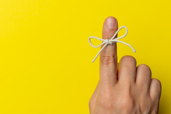 Optimising your memory image - finger with string tied around it against yellow background