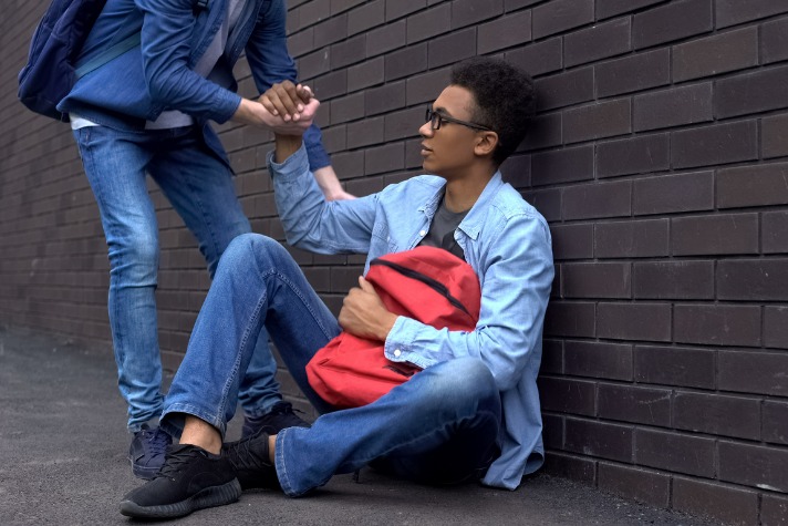 youth support worker helping a homeless youth in an alley